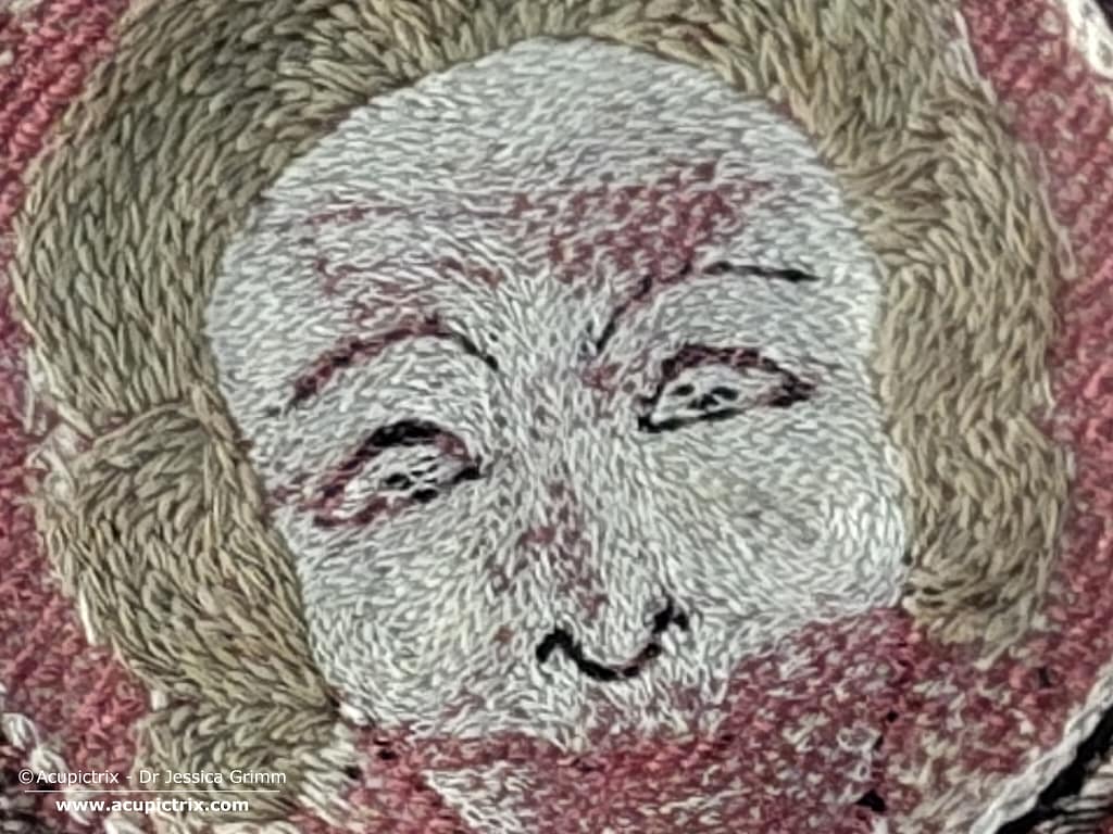 Opus anglicanum - an example of a face stitched in fine directional split stitch.