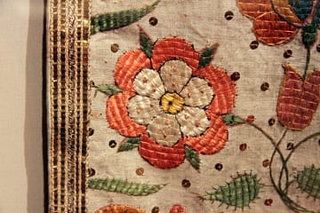 Linen Vestments Tyrol - an embroidered chasuble displayed in a glass case