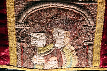 Medieval goldwork - multicoloured embroidered cross on a red chasuble