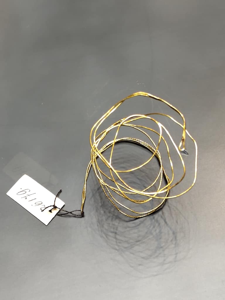 Gold threads - a coil of gold thread with a label